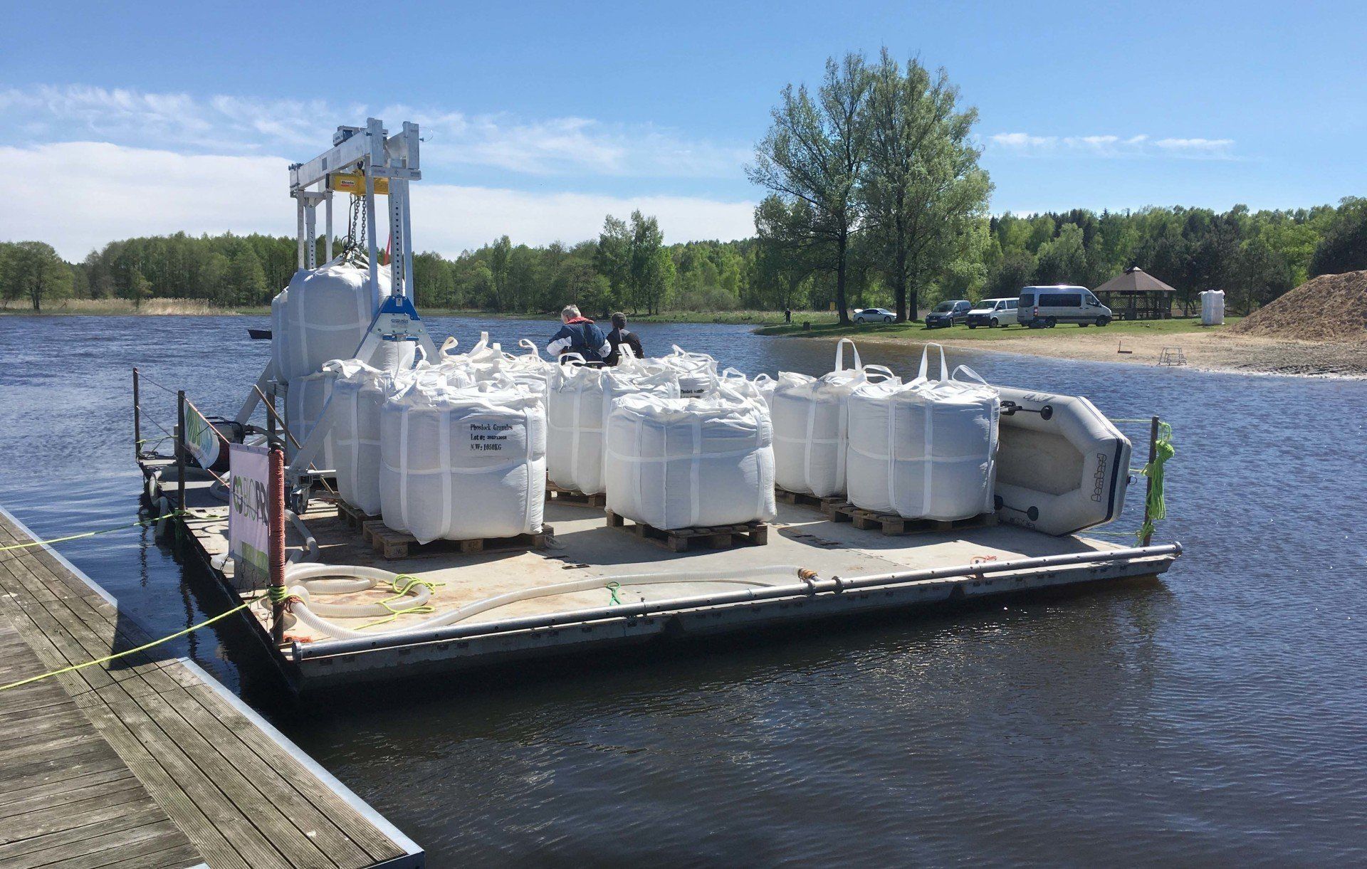 A dock filled with lots of white bags on a body of water