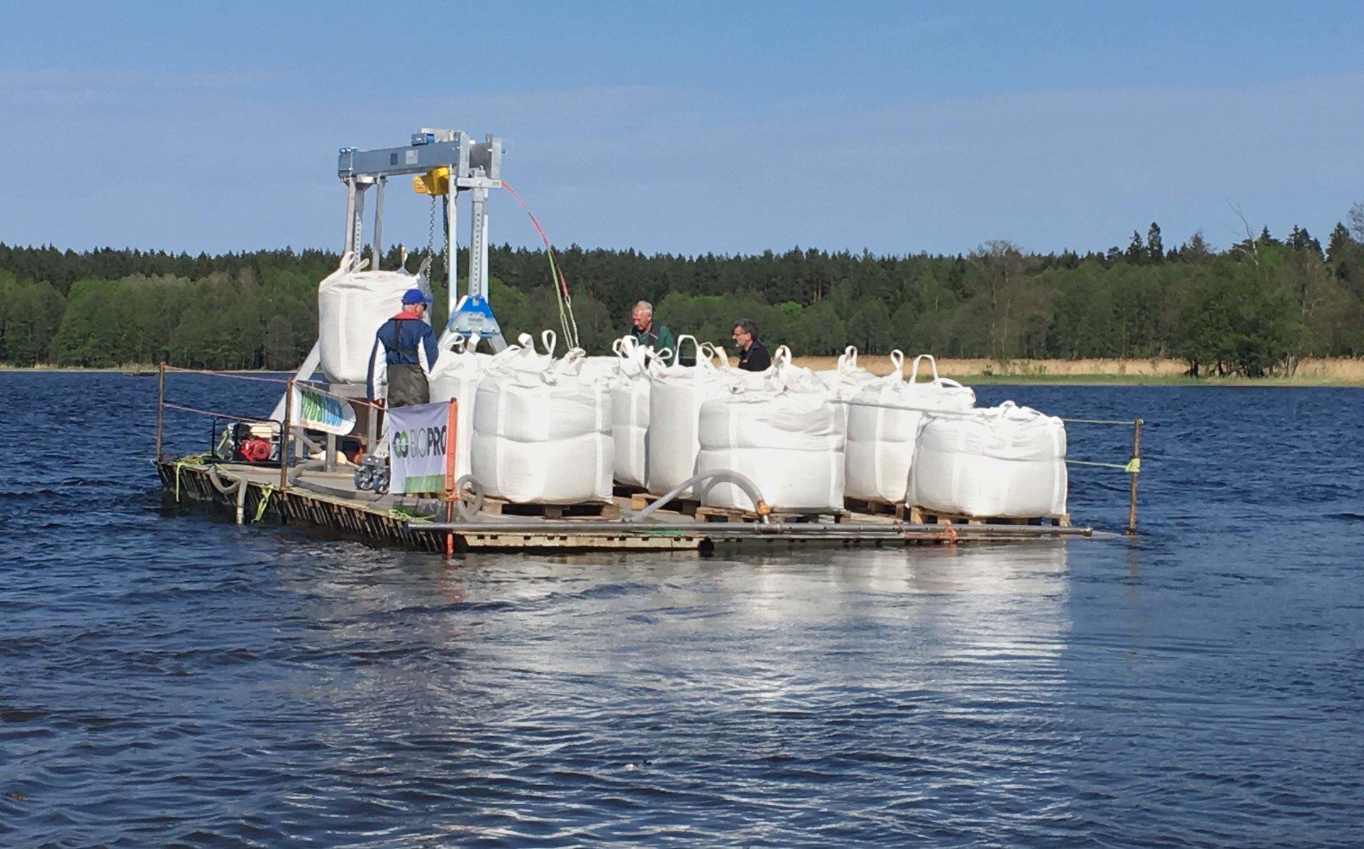 A raft filled with bags is floating on top of a lake.