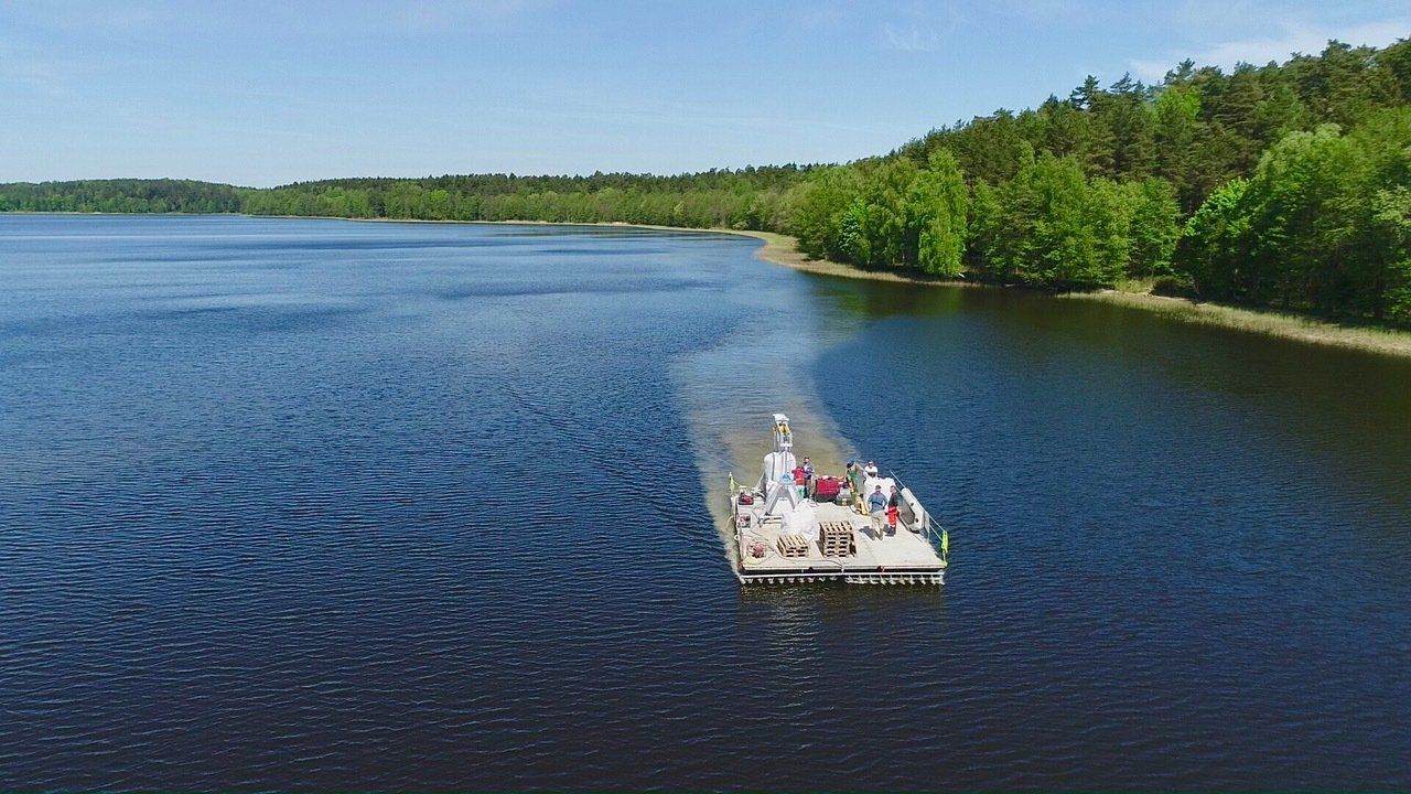 A boat with people on it is floating on a lake.