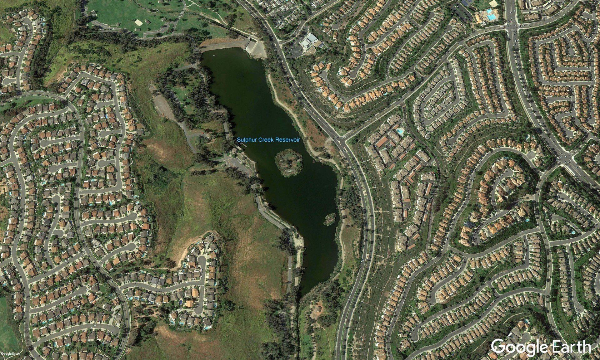 An aerial view of a lake in a residential area
