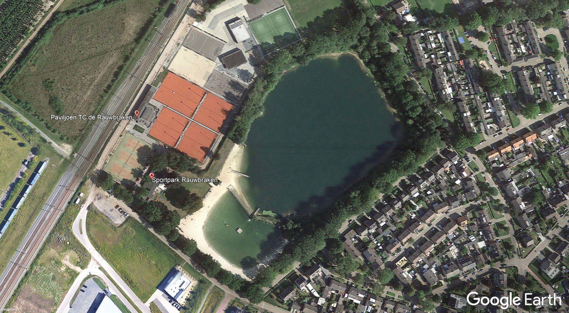An aerial view of a tennis court and a lake