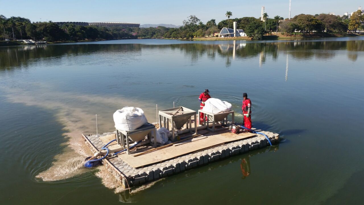A group of people are standing on a raft in the middle of a lake.
