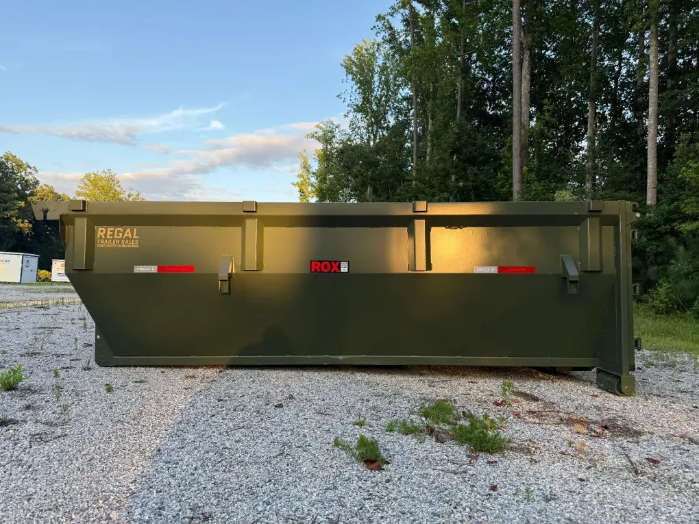 A dog is standing in front of a dumpster.