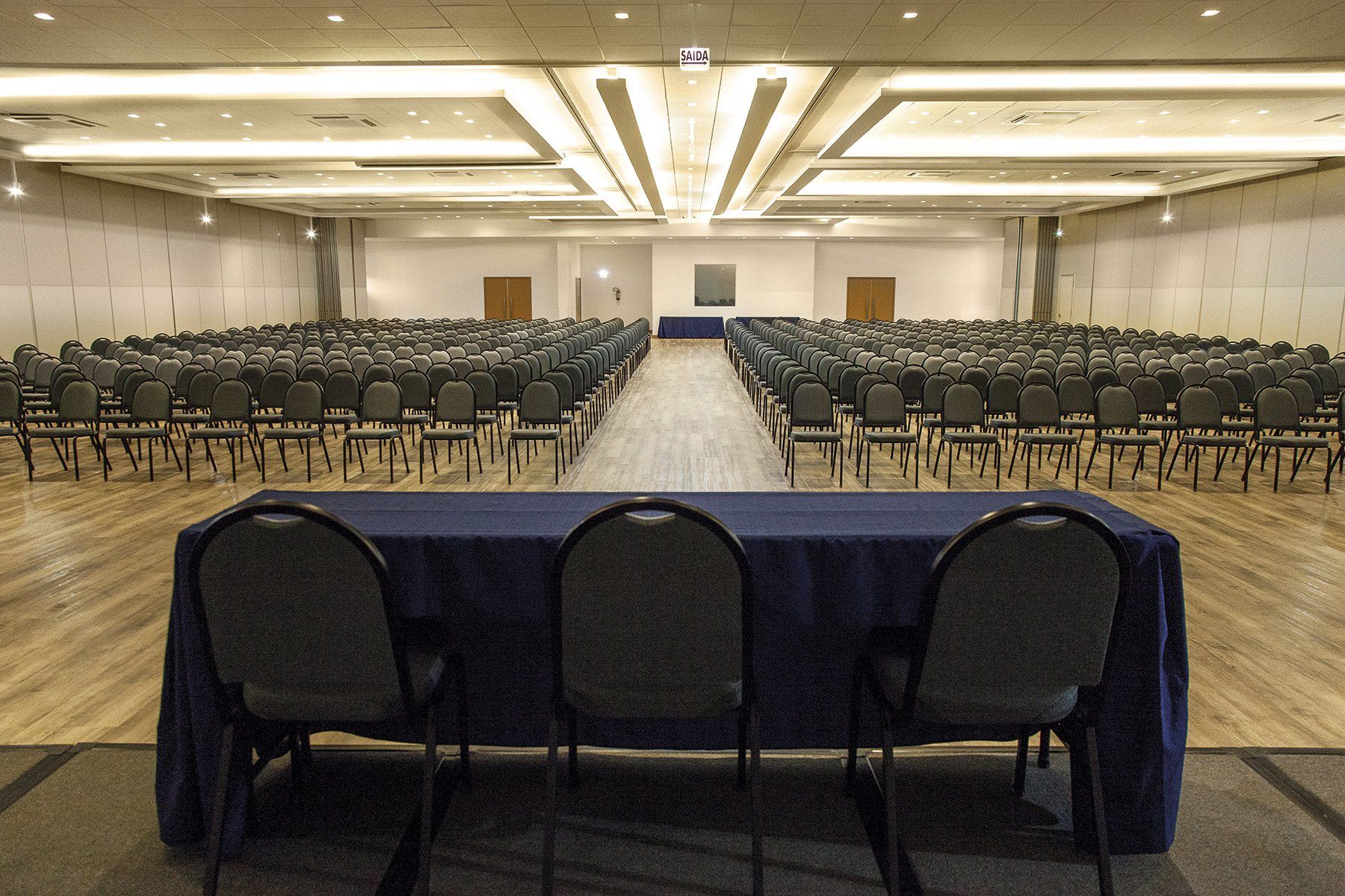 Uma sala de conferências vazia com mesa e cadeiras azuis