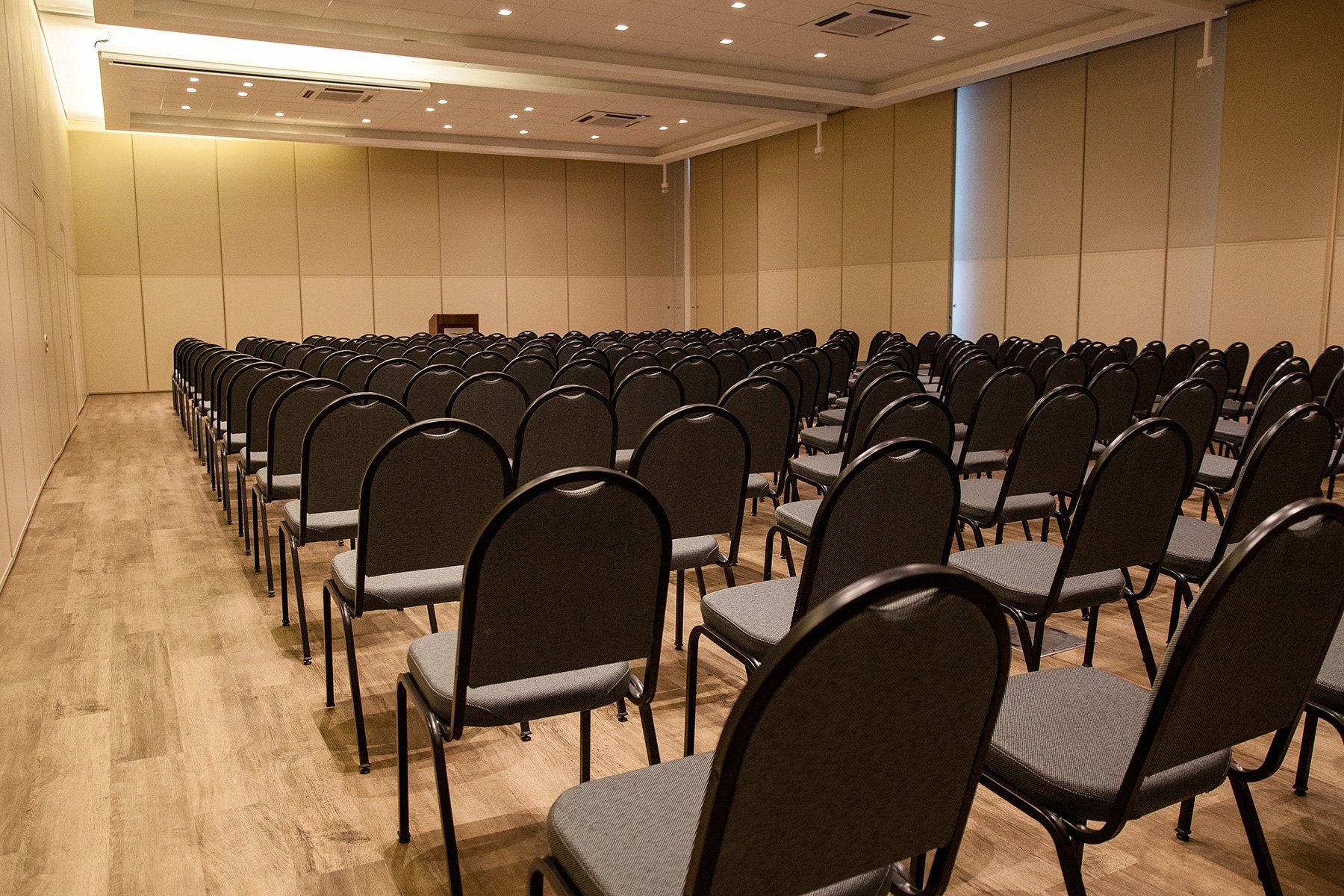 Fileiras de cadeiras vazias em uma grande sala de conferências