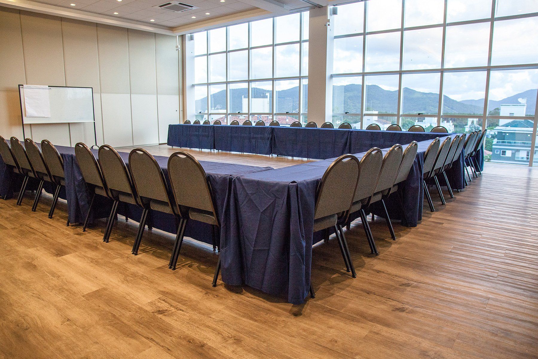 Uma sala de conferências com mesas e cadeiras e uma grande janela.