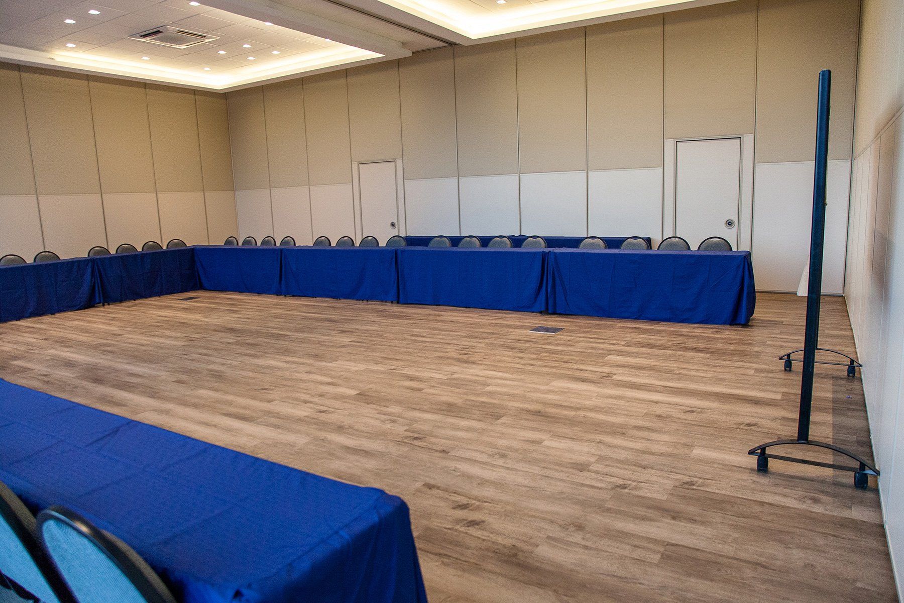 Uma sala de conferências vazia com mesas e cadeiras azuis