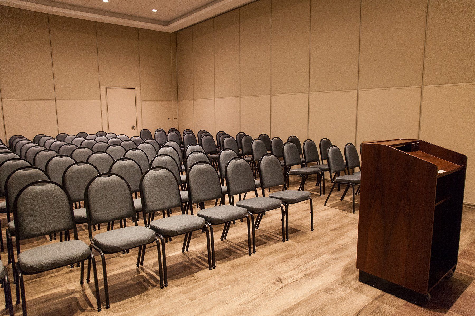 Uma sala de conferências com fileiras de cadeiras e um pódio