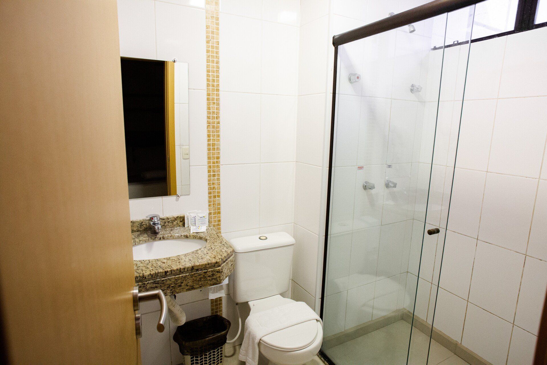 Um banheiro com vaso sanitário, pia e chuveiro.
