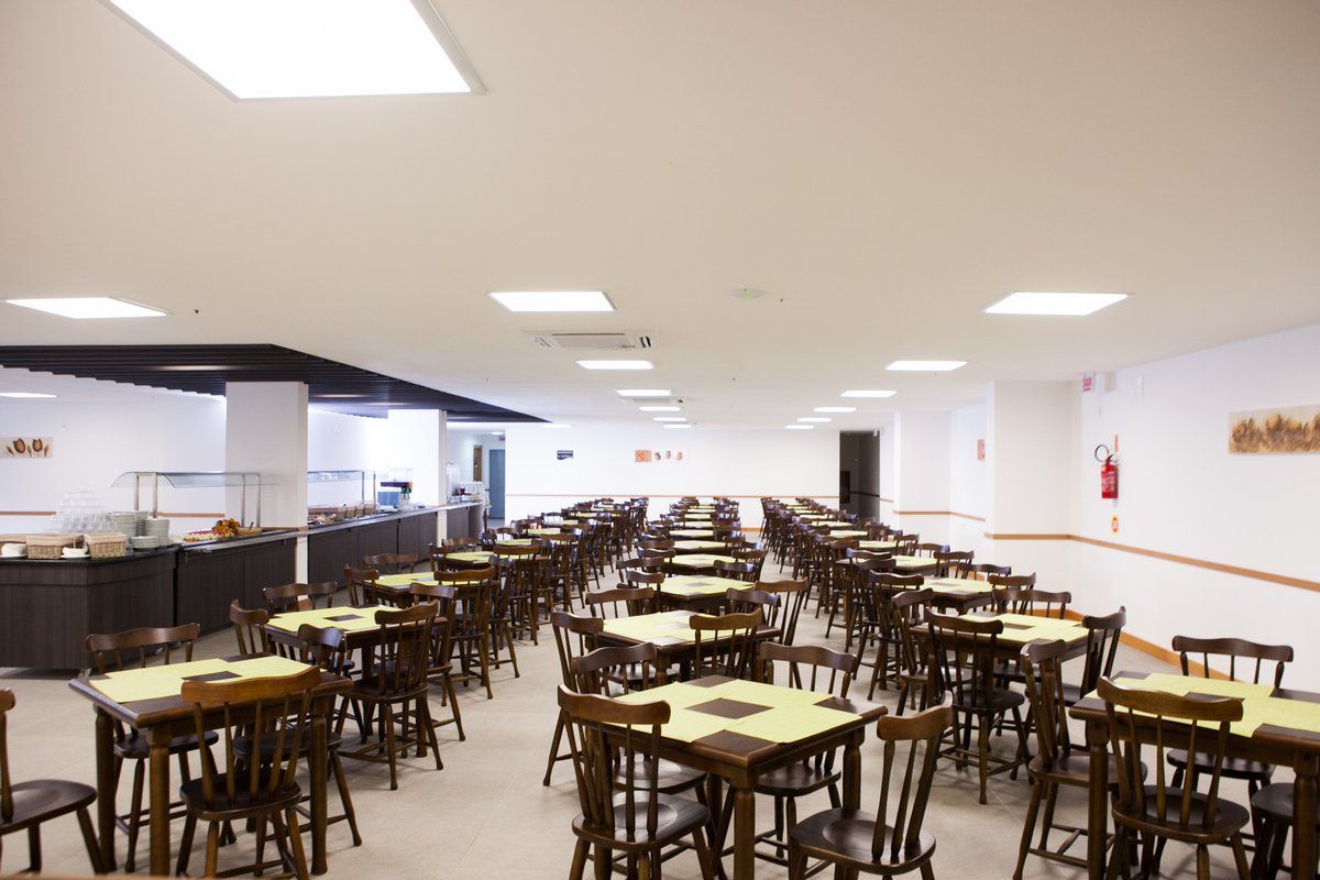 Uma grande sala com mesas e cadeiras em um restaurante
