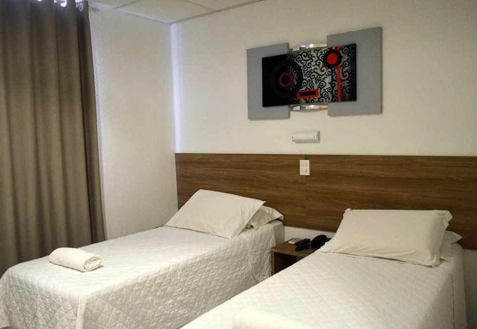 Um quarto de hotel com duas camas e uma pintura na parede