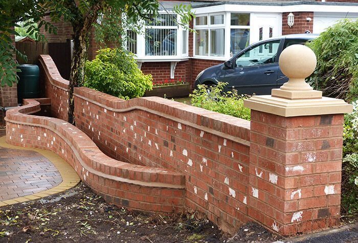 A brick wall with a car parked in front of it