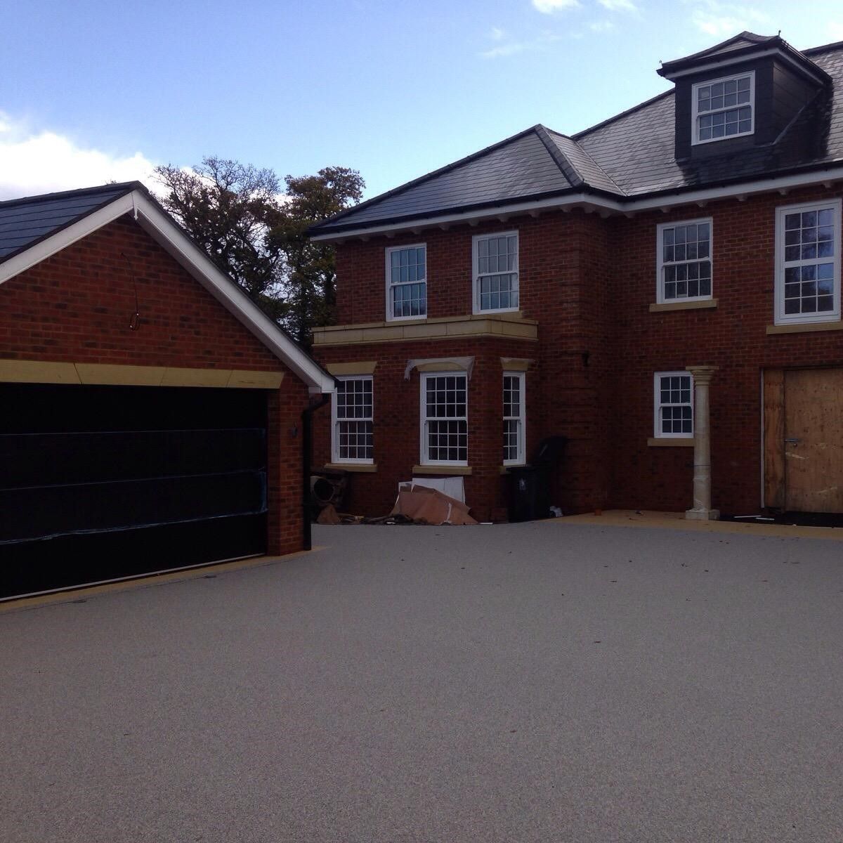 A large brick house with a black garage door