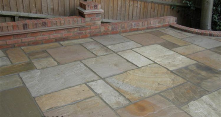 A stone patio with a brick wall in the background.