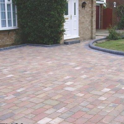 A brick driveway in front of a brick house.