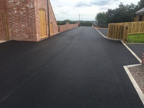 A road with a brick building on the side of it