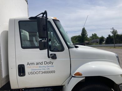 White delivery truck parked outdoors with driver-side door open and company logo on the door