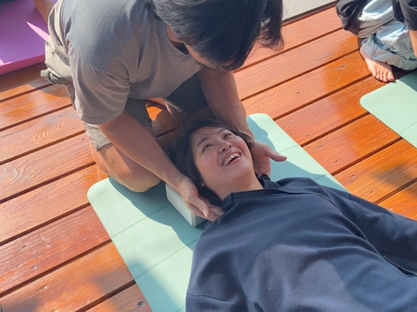 A man is giving a woman a massage on a yoga mat