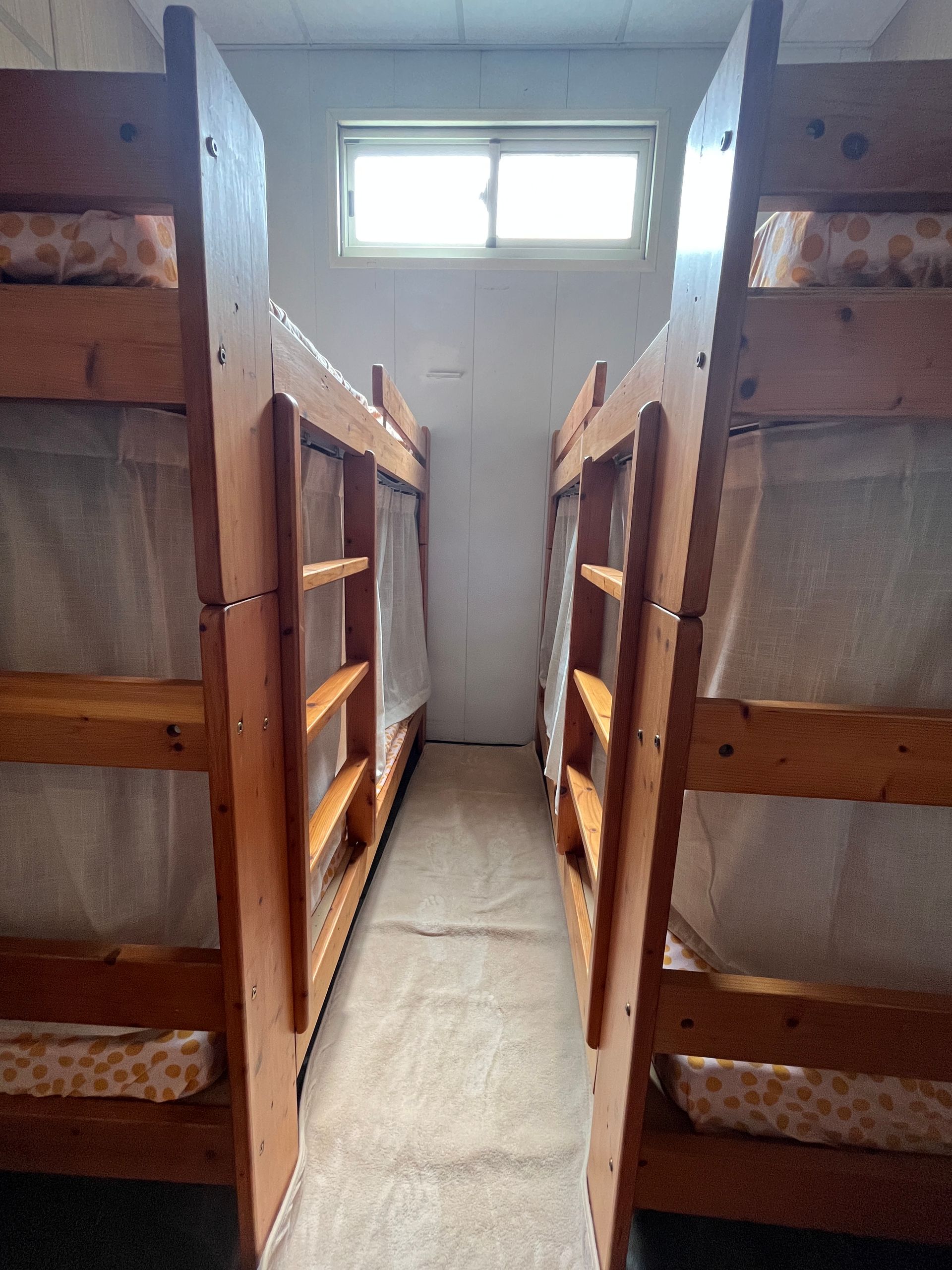 A row of bunk beds in a room with a window