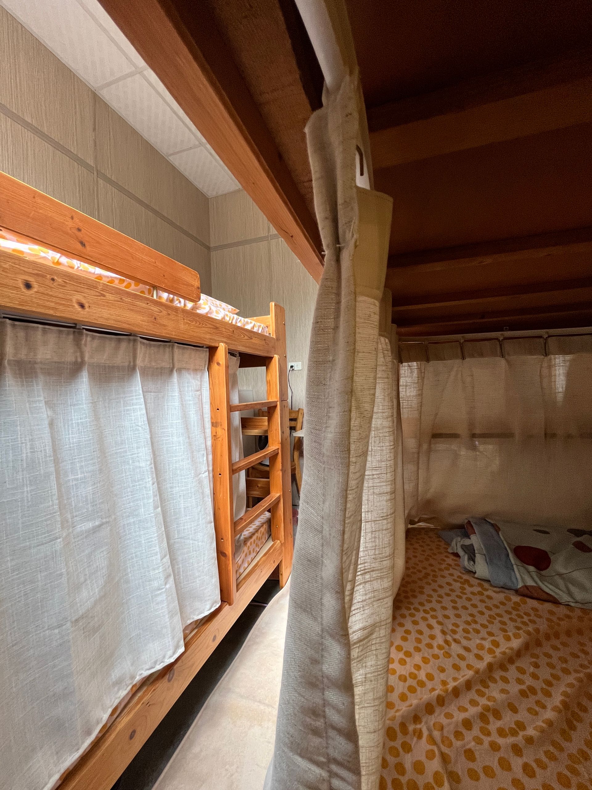 A bunk bed with a curtain between the beds