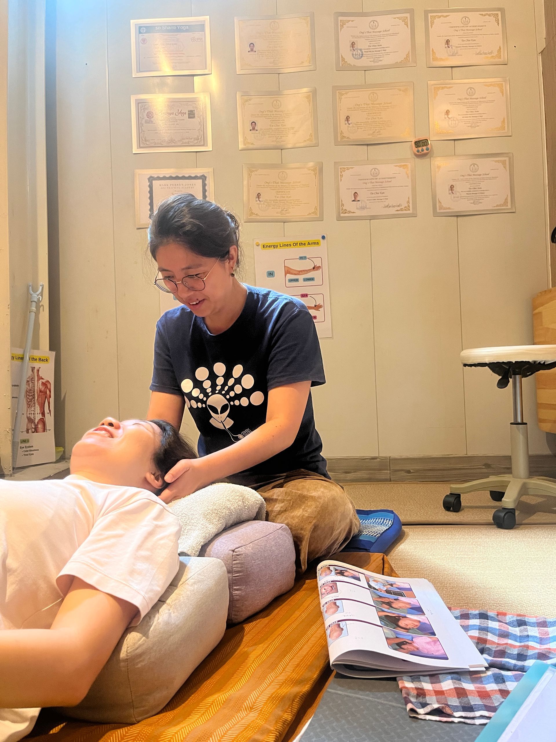 A man is laying on a bed getting a massage from a woman wearing a mask.
