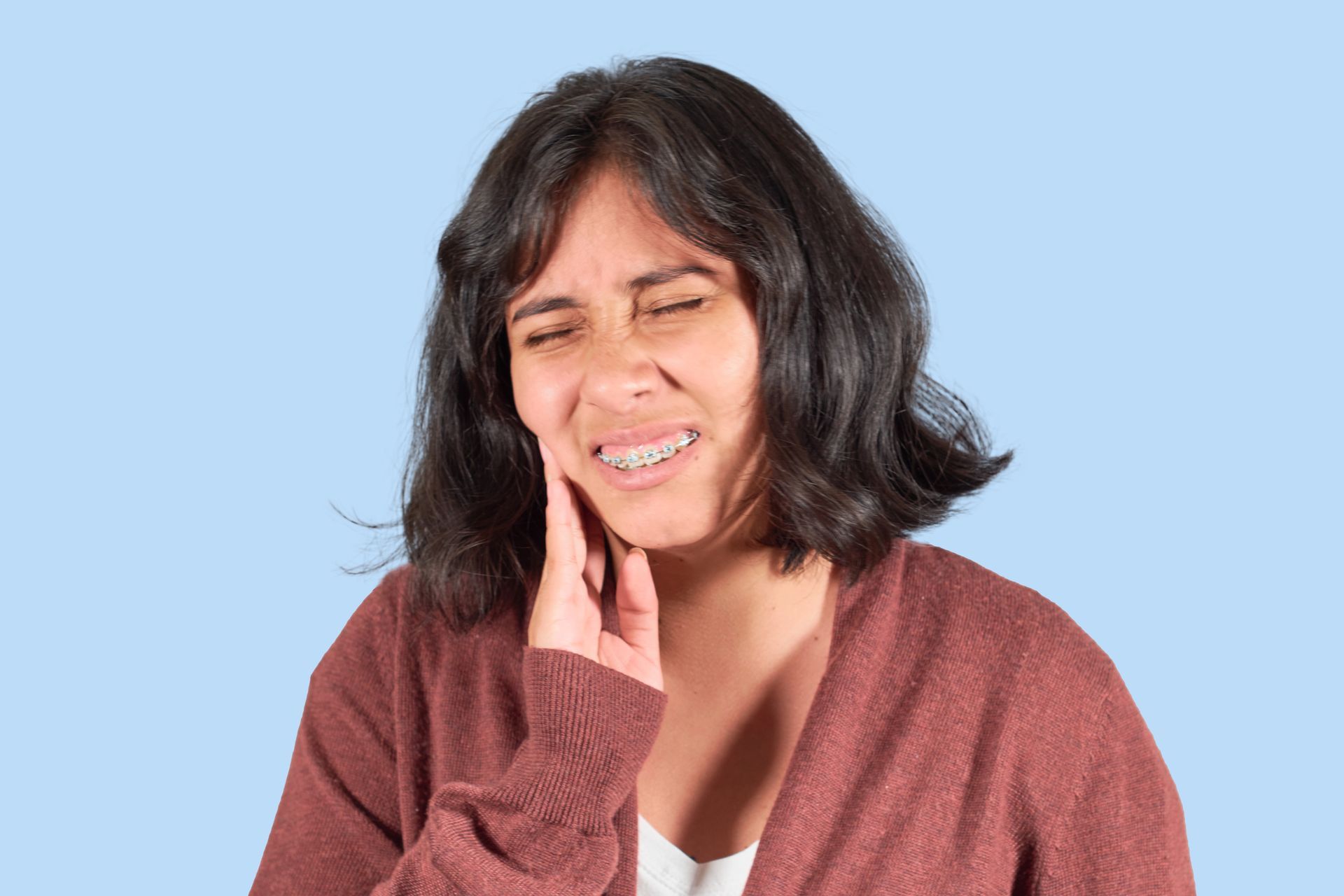 Woman frowning from braces discomfort in Bedford, TX, highlighting common pain points and solutions 