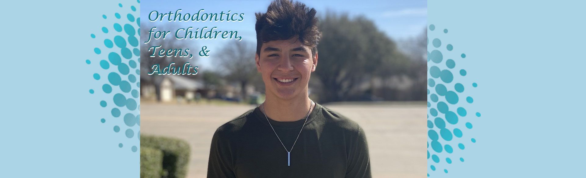 Smiling person, a teen, outside in a black shirt; 