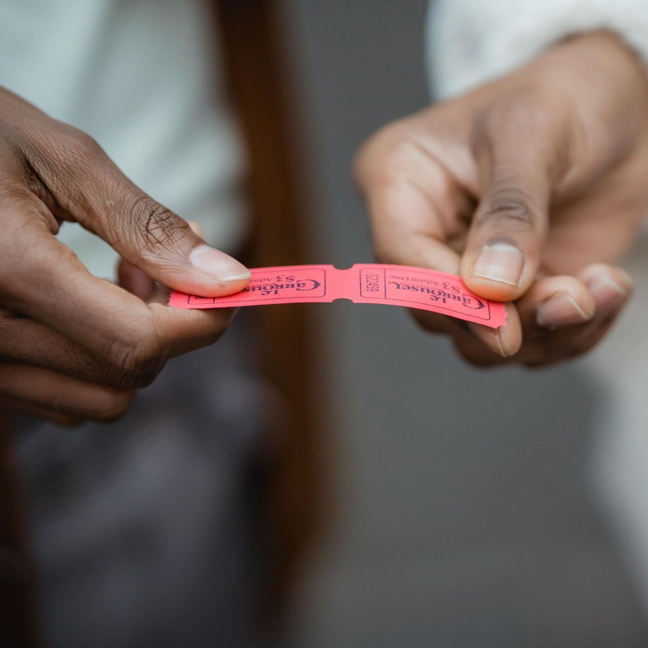 A close up of a person holding a red ticket