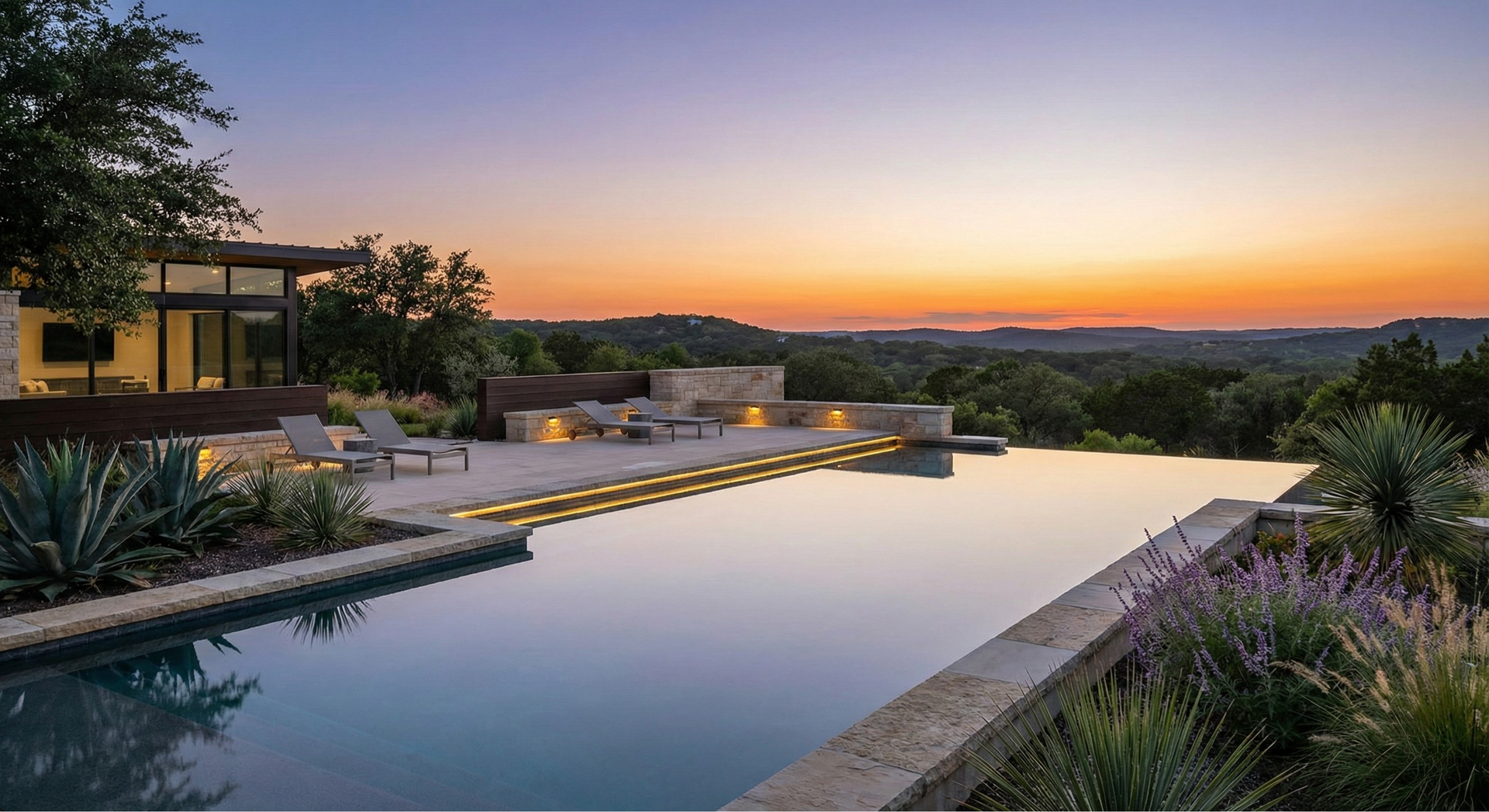 Infinity pool overlooking a scenic sunset, next to a modern home.