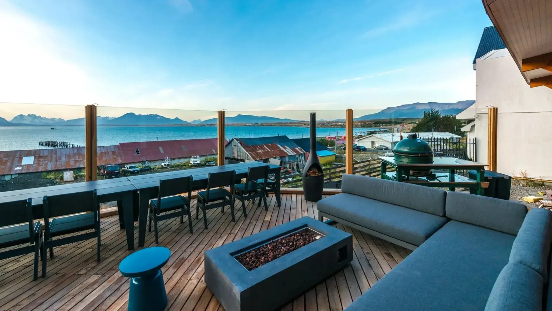 Deck with waterfront view; seating area with fire pit, grill, and dining table.