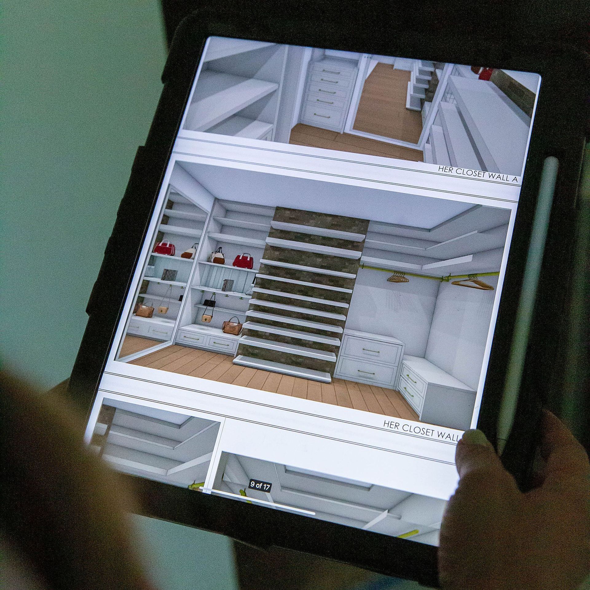 a person is holding a tablet with a picture of a closet on it