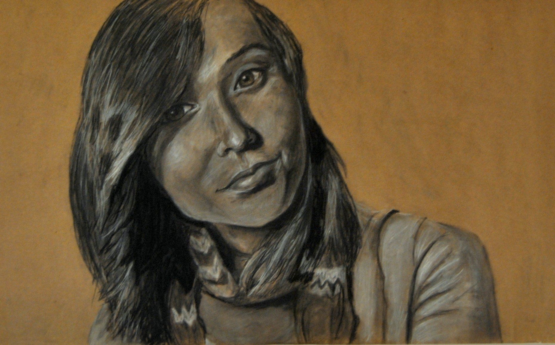 Charcoal portrait of a person with dark hair, a slight smile, and a patterned scarf.