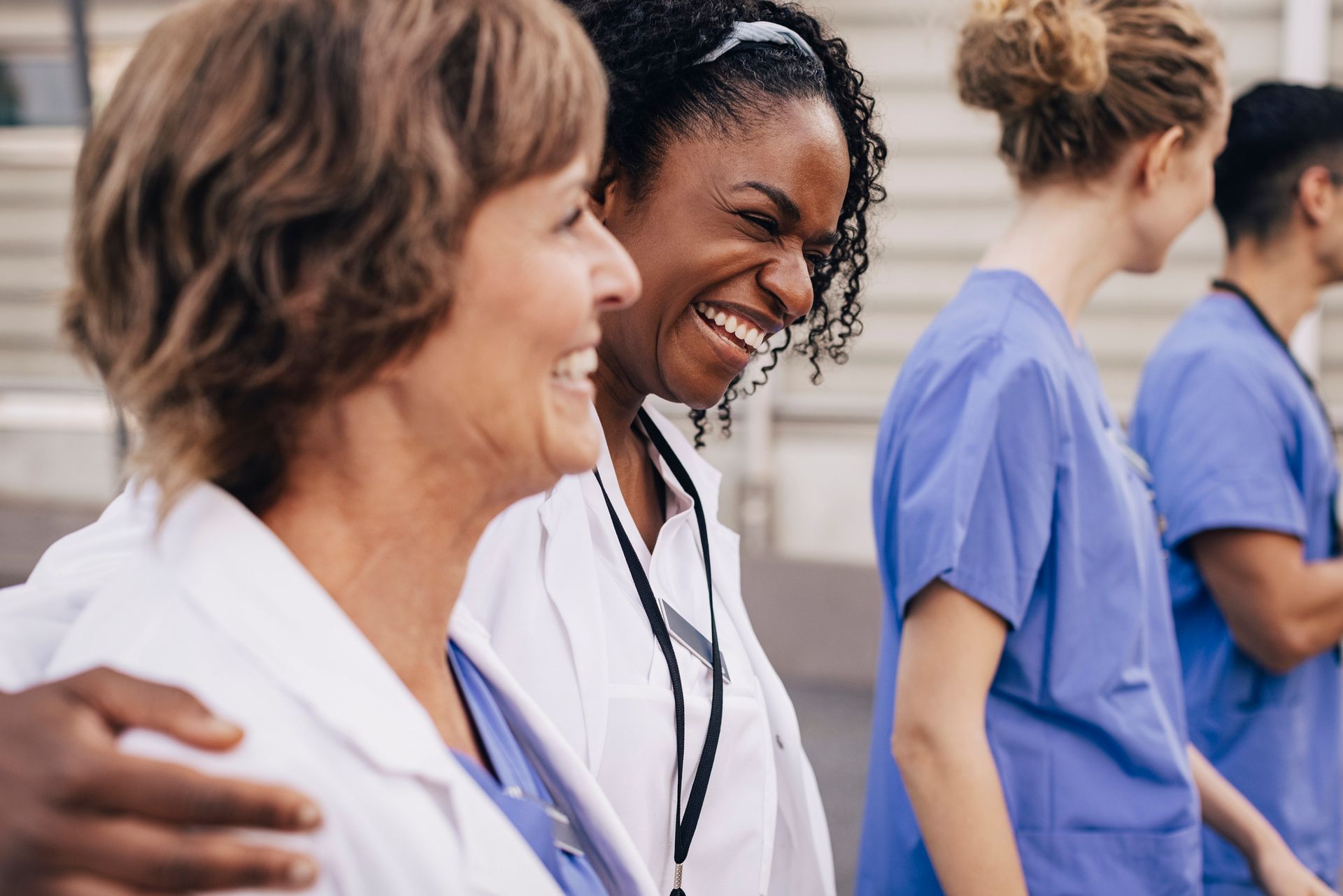 A group of nurses are standing next to each other and smiling.