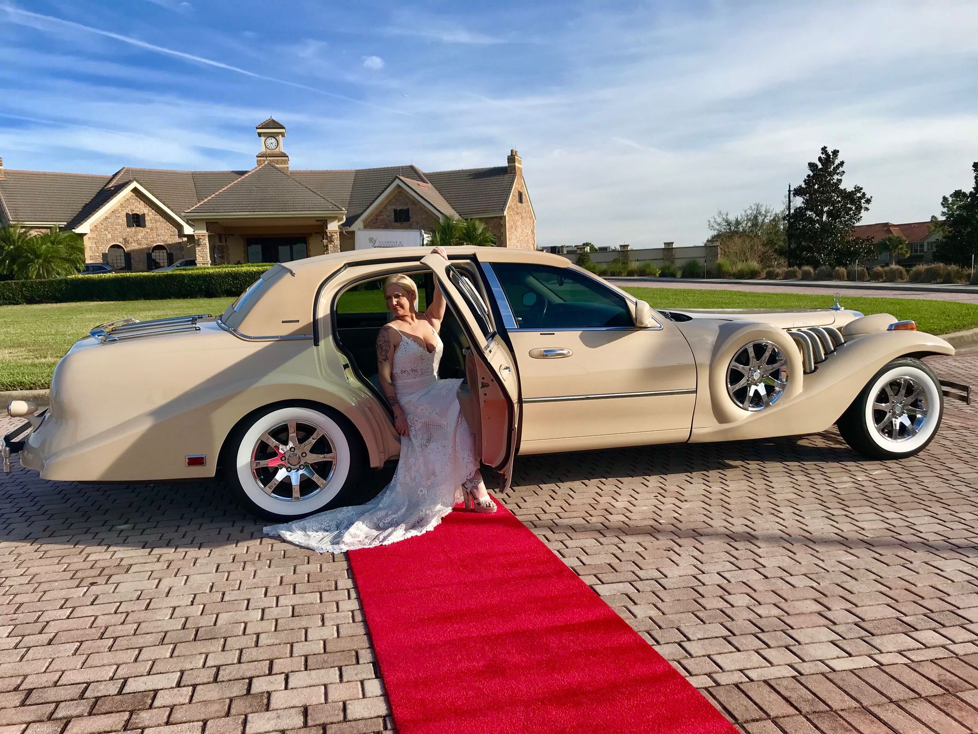 Exotic Limo Orlando Bride exiting a beige retro-style limousine onto a red carpet; wedding venue in background.