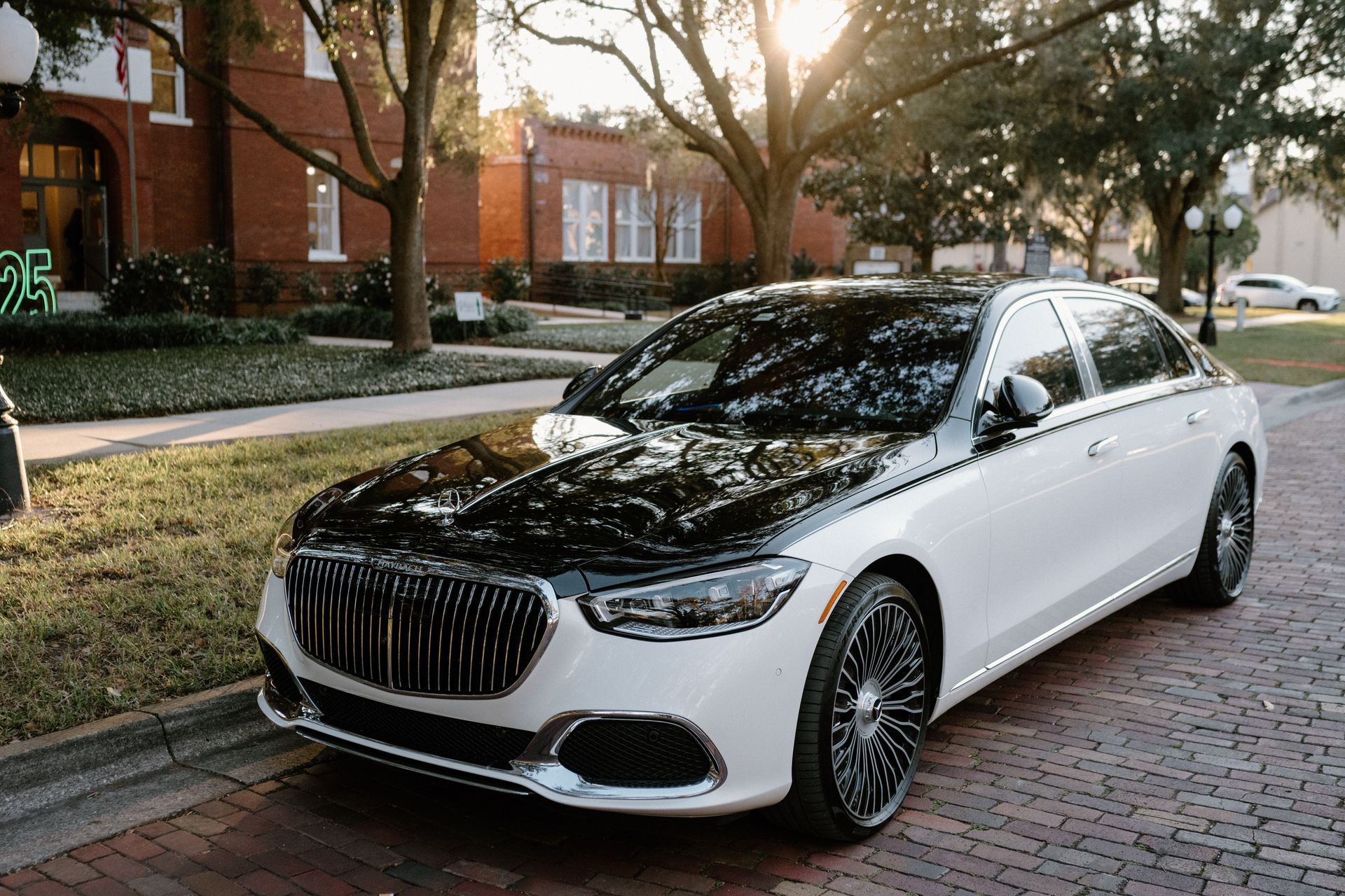 Exotic Limo Orlando White and black Mercedes sedan parked on a brick street with a building in the background.