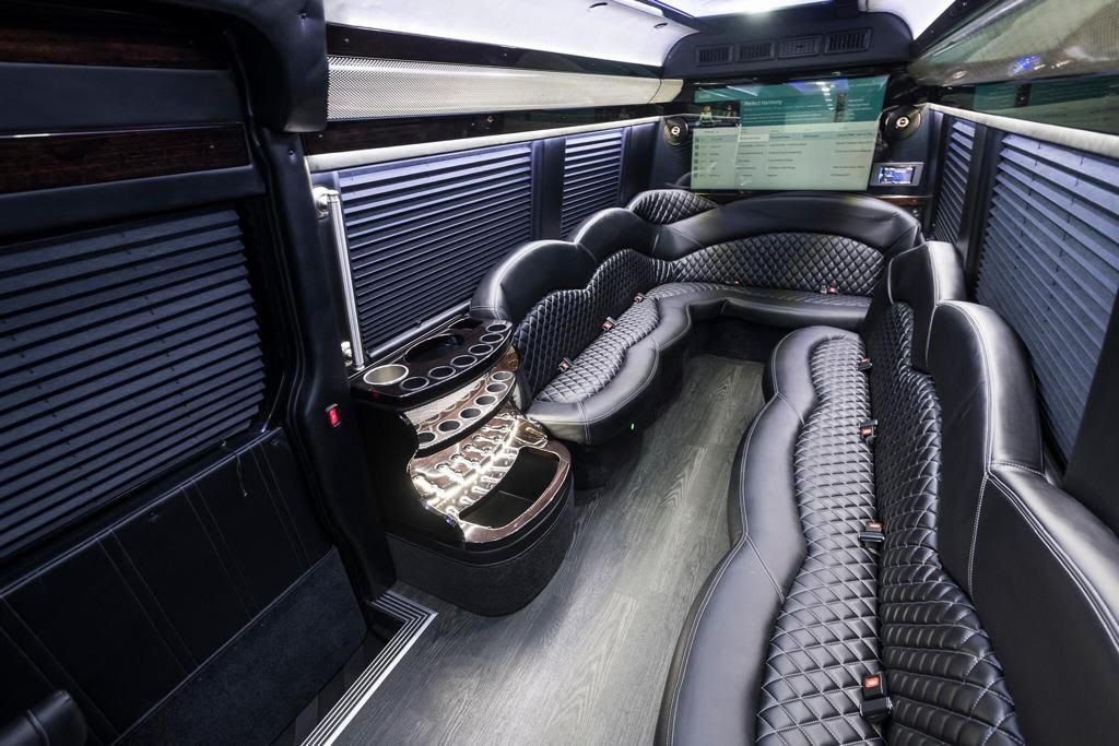 Interior of a black limousine with quilted gray and black seating.
