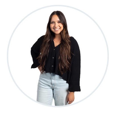 A woman in a black shirt and blue jeans is standing in a circle.