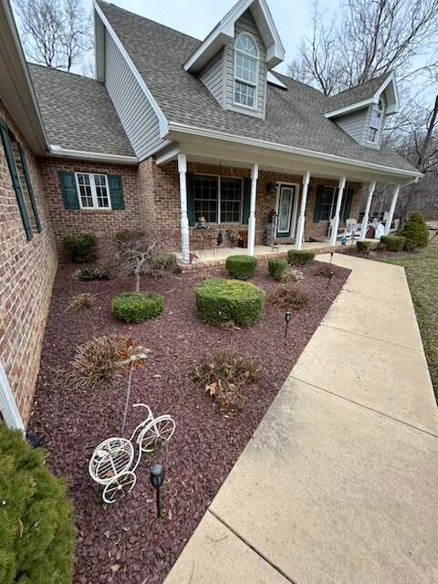 Brick house with white porch columns, landscaped front yard, and curved concrete walkway