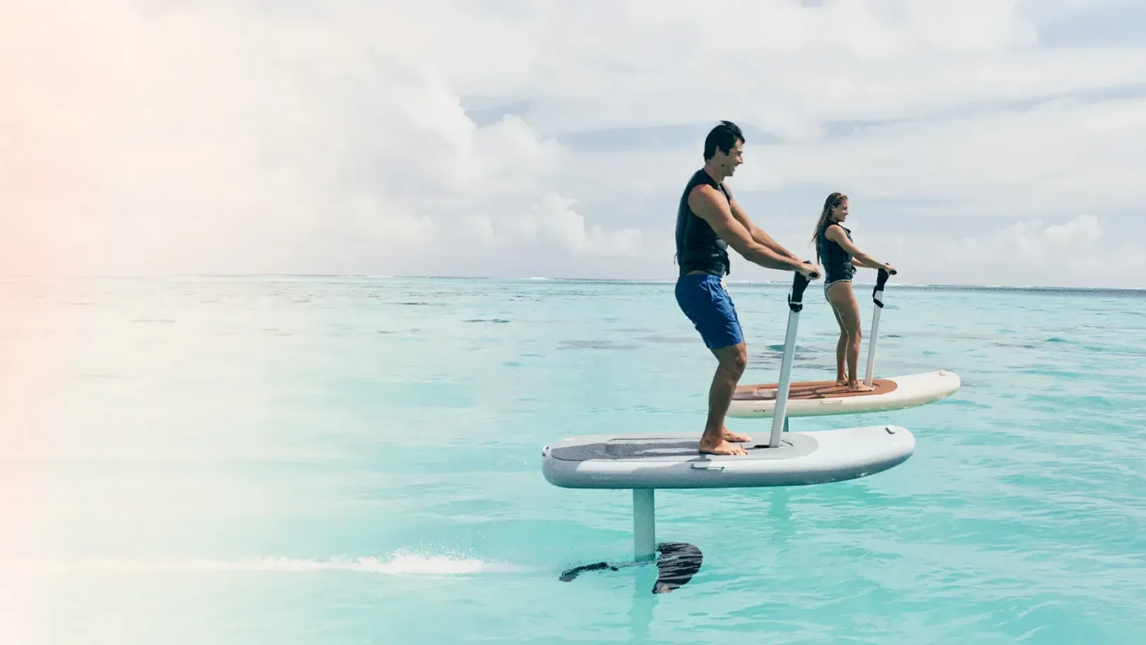 Un homme et une femme font du foil dans l'océan.