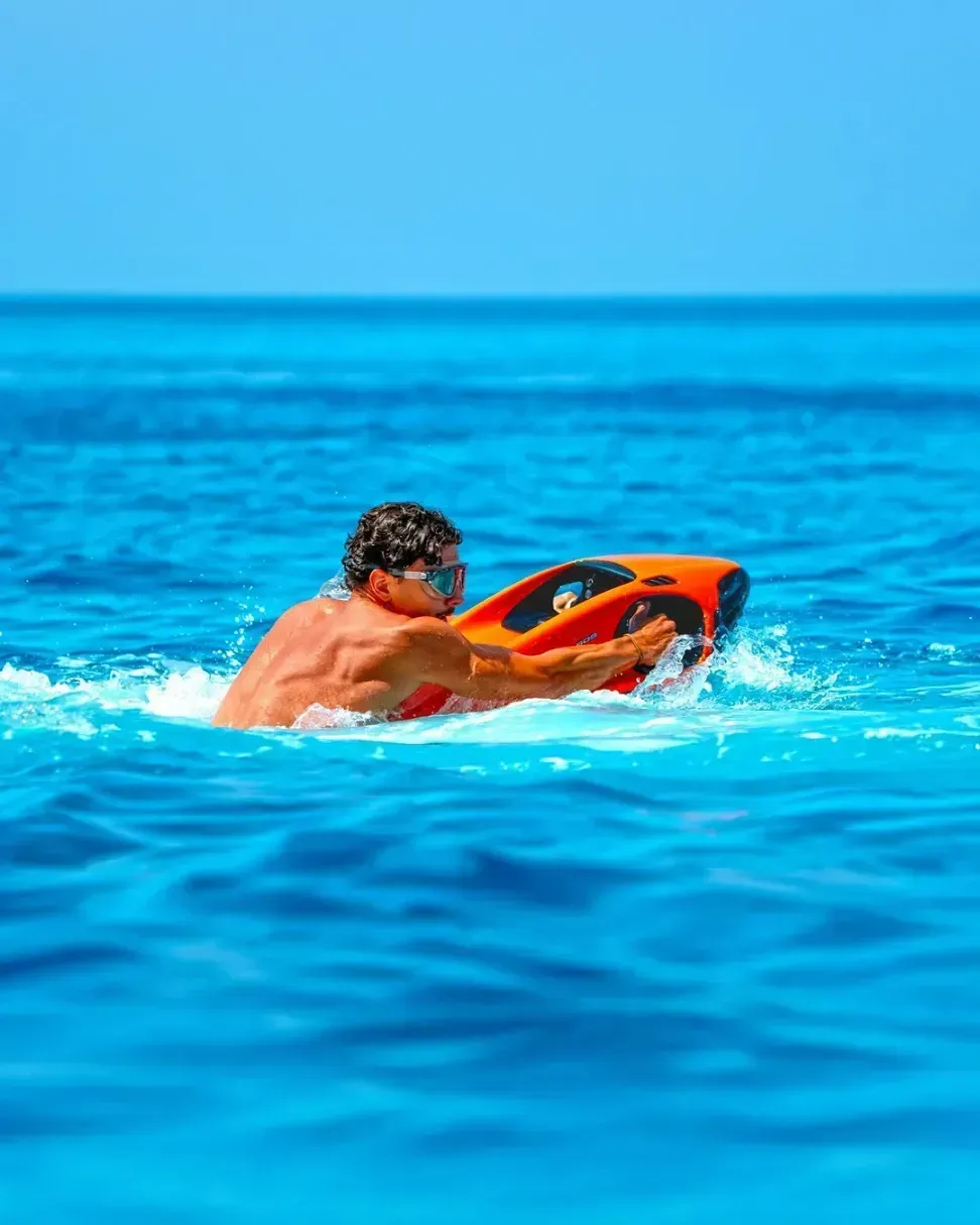 Homme qui flotte avec son seabob rouge