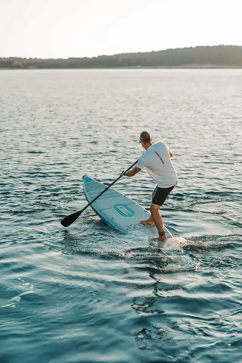 Homme qui rame sur sipaboard sur la mer