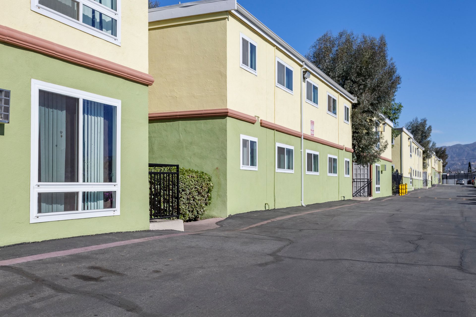 A row of apartment buildings with a parking lot in front of them