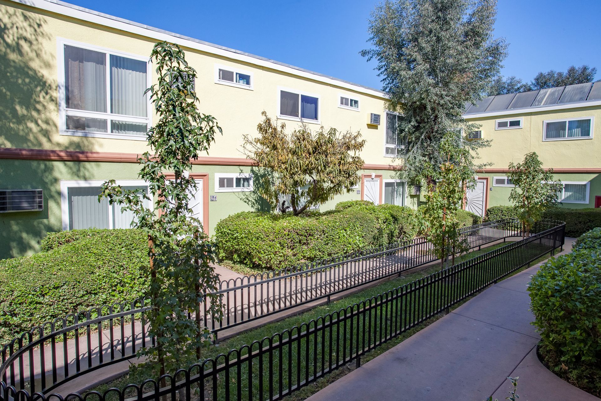 A walkway leading to a building with a fence around it