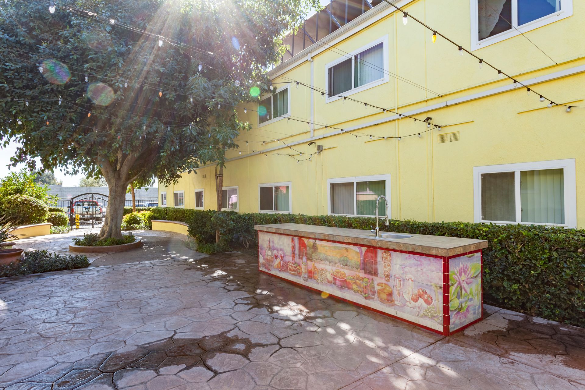 A yellow building with a wooden table in front of it.