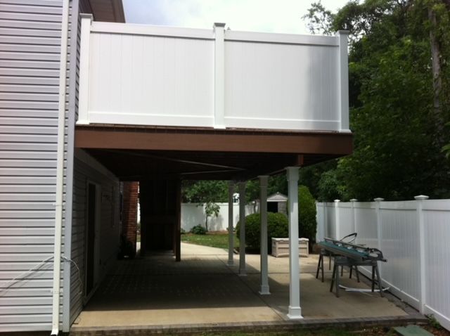 A white house with a white fence and a white deck