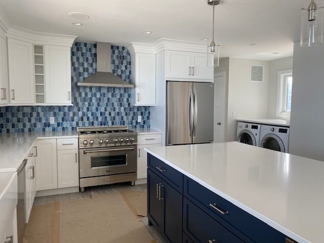 A kitchen with blue cabinets and white counter tops
