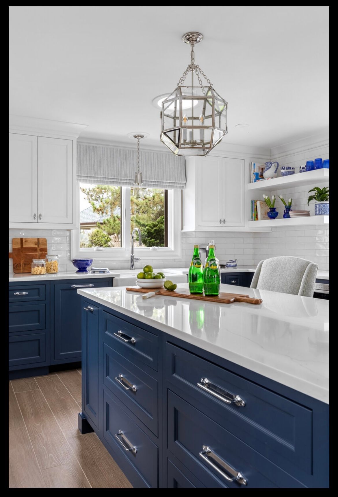 A kitchen with blue cabinets and white counter tops
