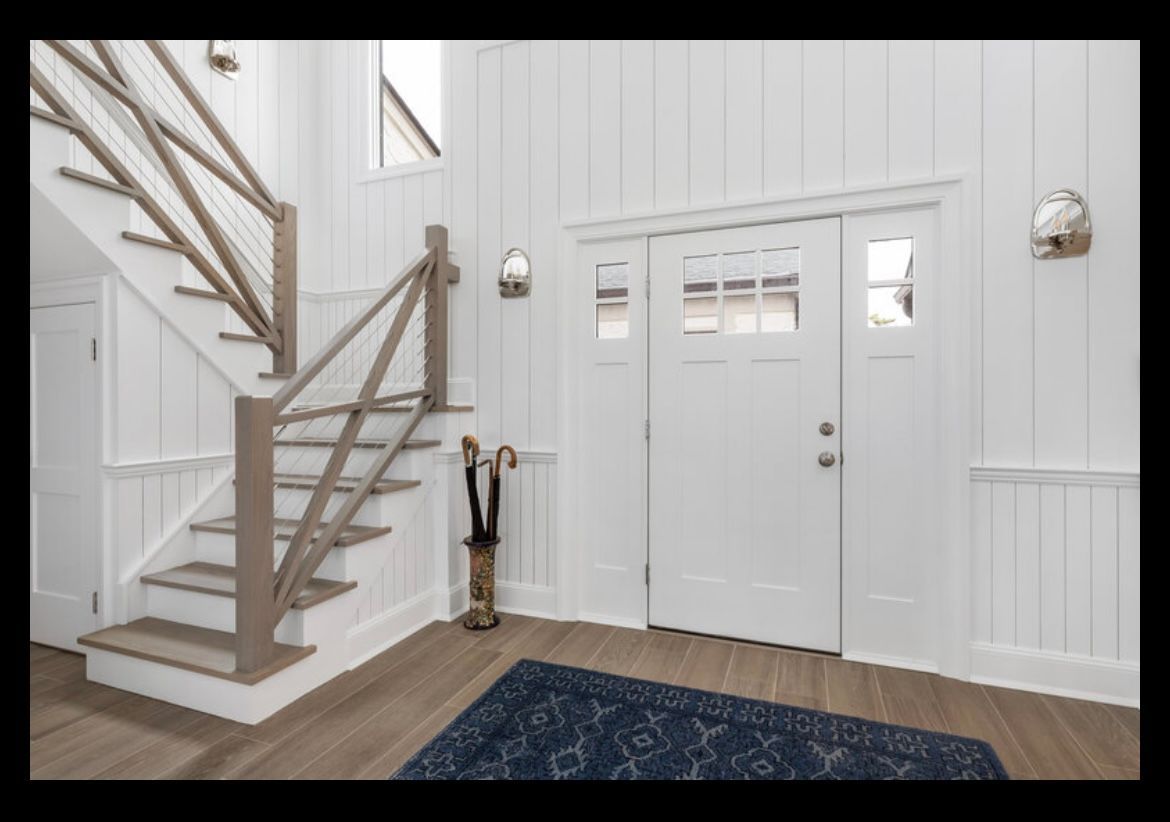 A hallway with stairs and a white door