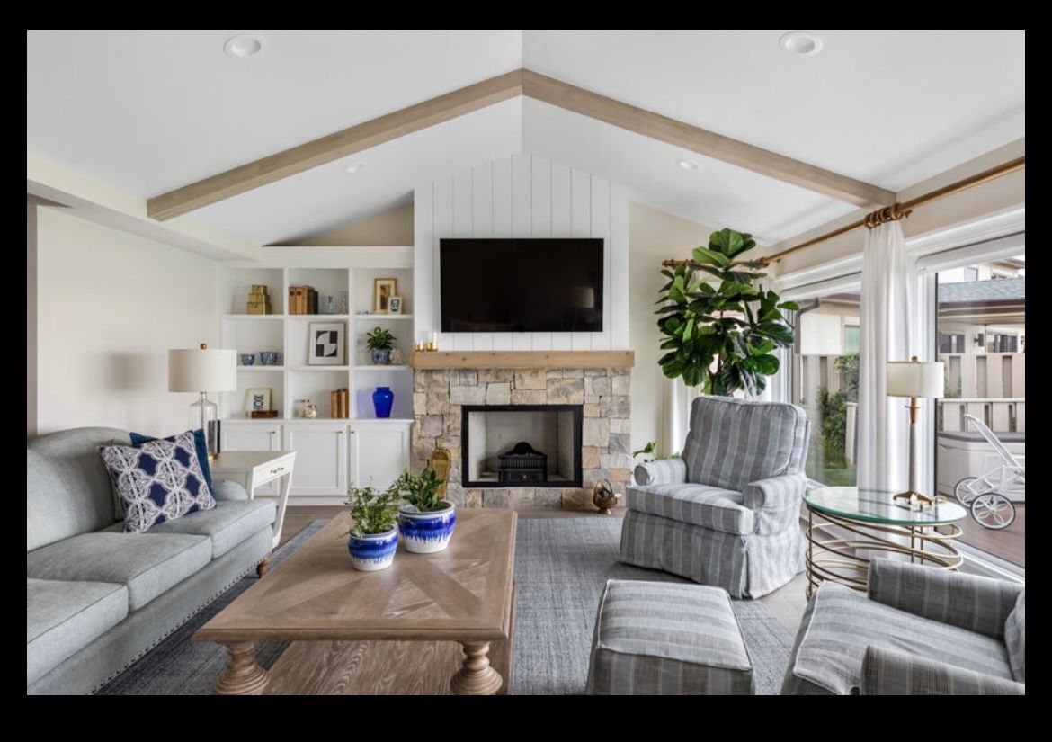 A living room with a fireplace , couch , chairs , coffee table and television.