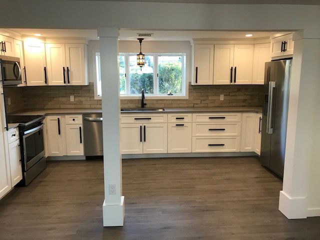 A kitchen with white cabinets and stainless steel appliances